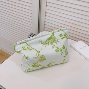 Gros plan de la broderie d'oiseaux sur une trousse de toilette en jacquard beige