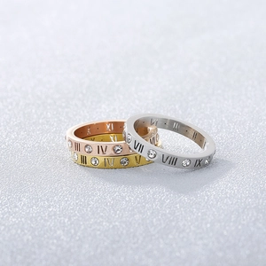 Detailed view of three-piece titanium steel rings with Roman numerals and inlaid diamonds