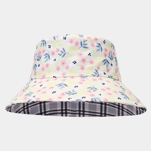 Detail of reversible sun hat showing yellow floral pattern and black-white checkered lining