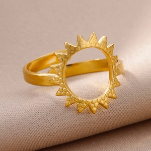 Macro shot of 18k gold plated stainless steel sunburst ring on elegant silk fabric
