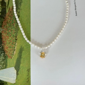 Detailed close-up of a 925 sterling silver pearl necklace with a golden rose flower pendant