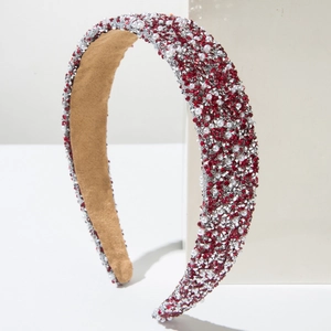 Luxe velvet headband with red crystals and pearls on white geometric display stand