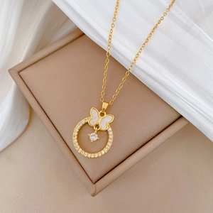 Close-up of golden butterfly necklace with mother-of-pearl and sparkling zircon inlays