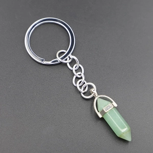 Macro view of light green hexagonal crystal stone pendant with silver metal key ring