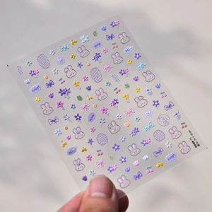 Macro shot of 3D embossed purple rabbit nail stickers with floral and bow patterns