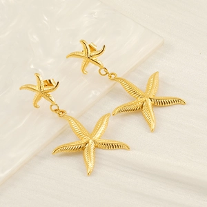 Elegant gold starfish drop earrings with double layered charms on a clean white background
