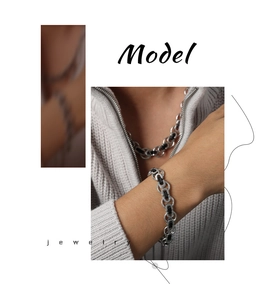 Detailed view of silver titanium steel chain necklace and bracelet set on male model