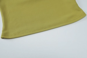 Détail macro du tricot côtelé vert olive avec ourlet précis à double couture sur le bas