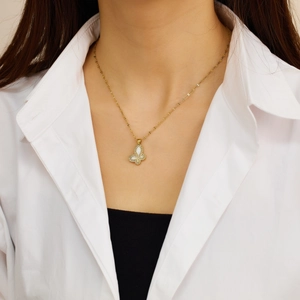 Golden butterfly pendant necklace with mother-of-pearl inlay worn on a model