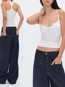 Canotta bianca aderente con jeans blu a gamba larga per un look estivo minimalista e fresco