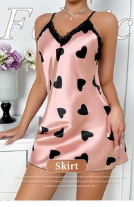 Close-up of bright pink satin nightdress with black hearts and lace neckline trim