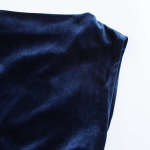 Detail of dark blue velvet fabric showing luxurious texture and soft sheen of the dress