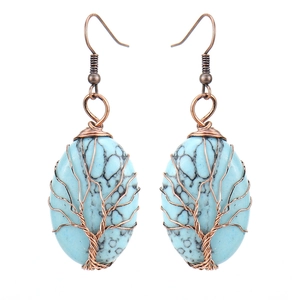 Detail of handmade wire wrapped tree of life earrings with oval turquoise stones