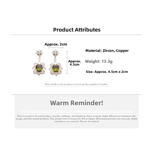 Detail view of floral drop earrings with green zircon and 925 silver needles