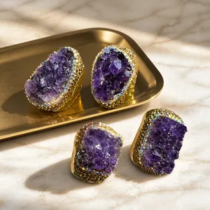 Dettaglio di anelli con druse di ametista naturale e bordi di strass scintillanti