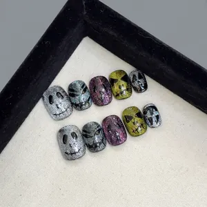Halloween cat eye press-on nails with short round shape and spooky skeleton designs