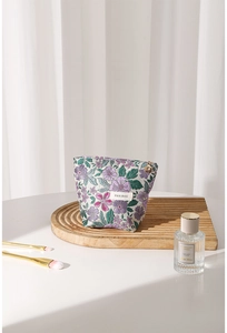 Detail of floral jacquard embroidery and elegant golden flower zipper on makeup bag