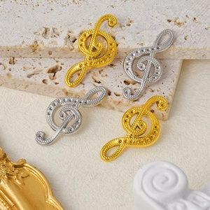 Detailed macro view of musical treble clef pendants in gold and silver stainless steel