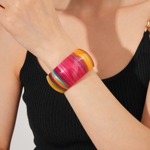 Close-up of vibrant rainbow striped resin cuff bracelet with polished glossy finish