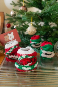 Gros plan de chaussettes de Noël épaisses en polaire corail avec rayures festives