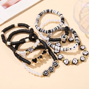 Detail of bohemian beaded bracelets with clay heishi beads and gold charms