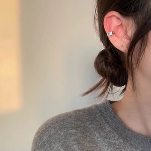 Minimalist S925 sterling silver irregular ear cuff shown on model in warm lighting