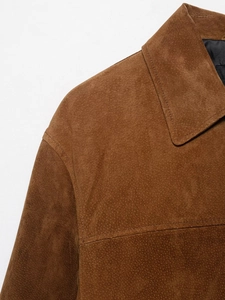 Detail of premium brown suede jacket showing high-quality collar and shoulder stitching