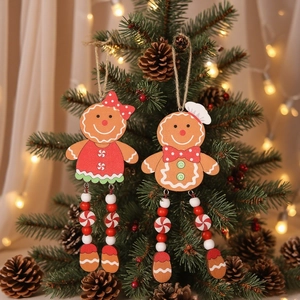 Wooden gingerbread couple Christmas tree ornaments with red beads in festive setting