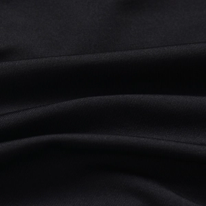 Dettaglio del vestito nero arricciato che mostra la trama a maglia e il tessuto elastico