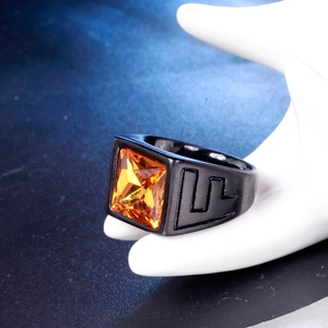 Macro view of vintage black stainless steel ring with a faceted orange square gemstone