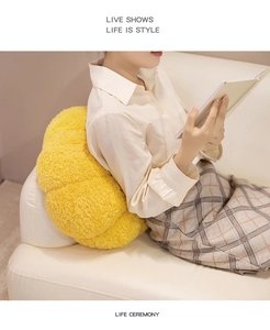 Bright yellow plush flower pillow cushion made of soft lamb wool on a white sofa