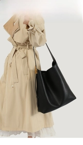 Detailaufnahme der schwarzen Tasche mit Litschi-Muster und goldener Metallschnalle