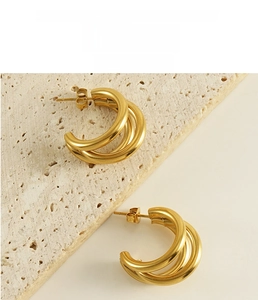 Detailed view of irregular 18K gold-plated stainless steel hoop earrings on stone