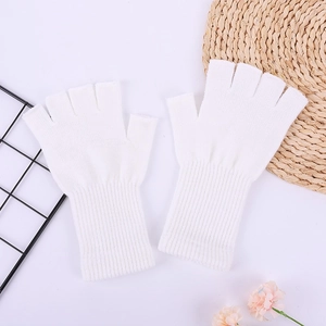 Close-up of white knitted fingerless gloves with ribbed cuffs on aesthetic background