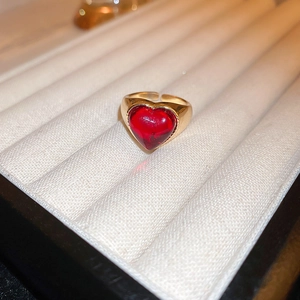 Detailed macro view of a gold-plated dragon ring featuring a large red heart-shaped gemstone