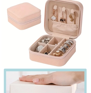 Detail of compact pink jewelry case with necklace hooks, ring slots and zipper closure