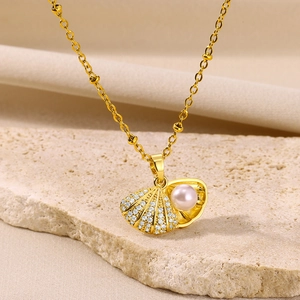 Close-up of shell locket pendant with diamonds and pink pearl on vintage gold chain