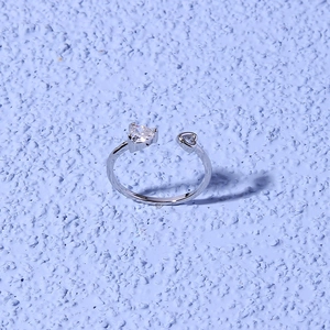 Macro shot of a silver heart ring featuring a large zircon stone and hollow heart frame