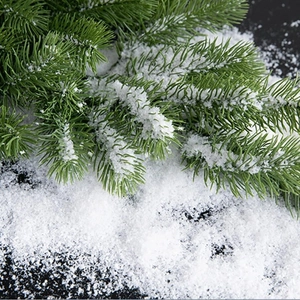 Artificial snow powder on green pine branches for Christmas window display decoration