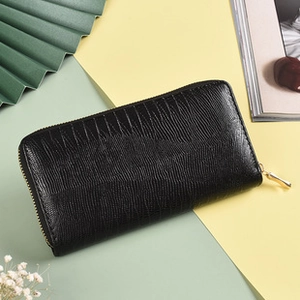 Detail of black textured leather long wallet with premium gold zipper on a creative background