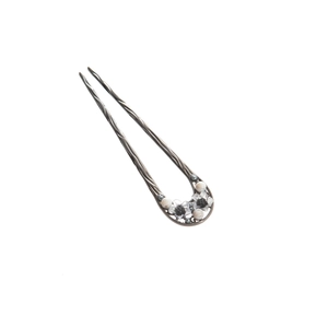Detailed macro view of retro silver U-shaped hair pin with delicate metal flowers and pearls