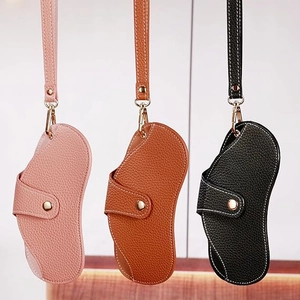 Close-up of litchi leather eyewear pouches in pink, tan and black with gold snap buttons