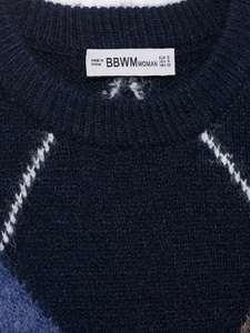 Close-up of knitted navy sweater collar showing fabric texture and brand size label