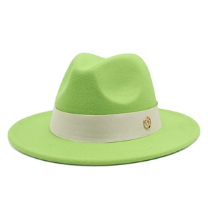 Close-up of wool fedora hat with beige ribbon and golden metallic circular logo detail