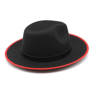 Detail of black wool fedora featuring a striking red brim edge and matching hat band