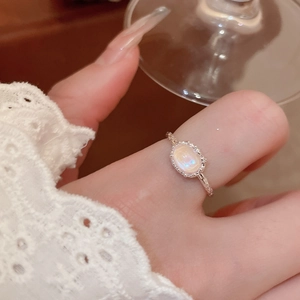 Close-up of vintage silver ring with oval iridescent shell stone and milgrain detail