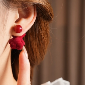 Close-up of a model wearing red flocking bear stud earrings with silver needles