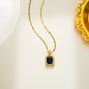 Vue macro du pendentif rectangulaire bleu avec chaîne dorée et micro-pierres incrustées