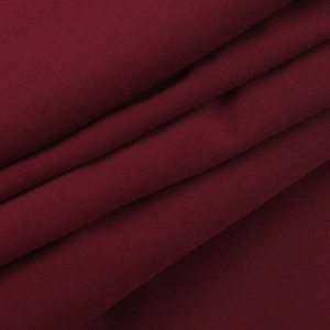Vue macro détaillée du tissu bordeaux avec un drapé élégant et une texture mate