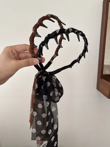 Detail view of anti-slip headbands with long polka dot streamers in black and brown